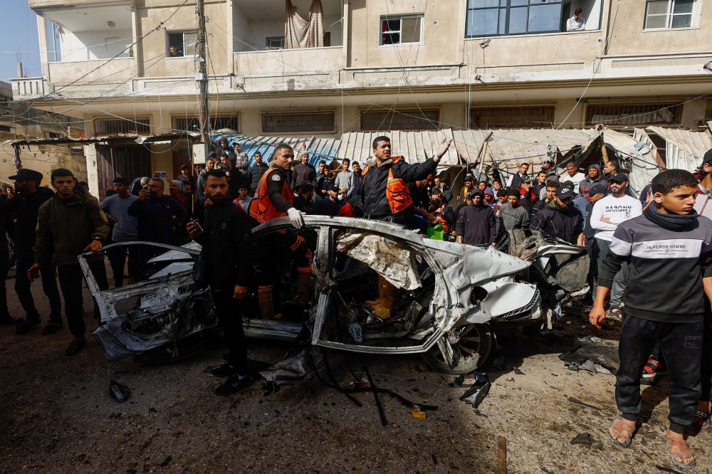Palestinians inspect the site of an Israeli strike on a car, amid the ongoing conflict between Israel and Hamas, in Rafah, southern Gaza Strip December 22, 2023. — Reuters pic 