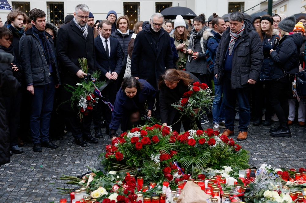 University workers lay tributes at a memorial during a vigil following a shooting at one of Charles University's buildings in Prague, Czech Republic December 22, 2023. ― Reuters pic