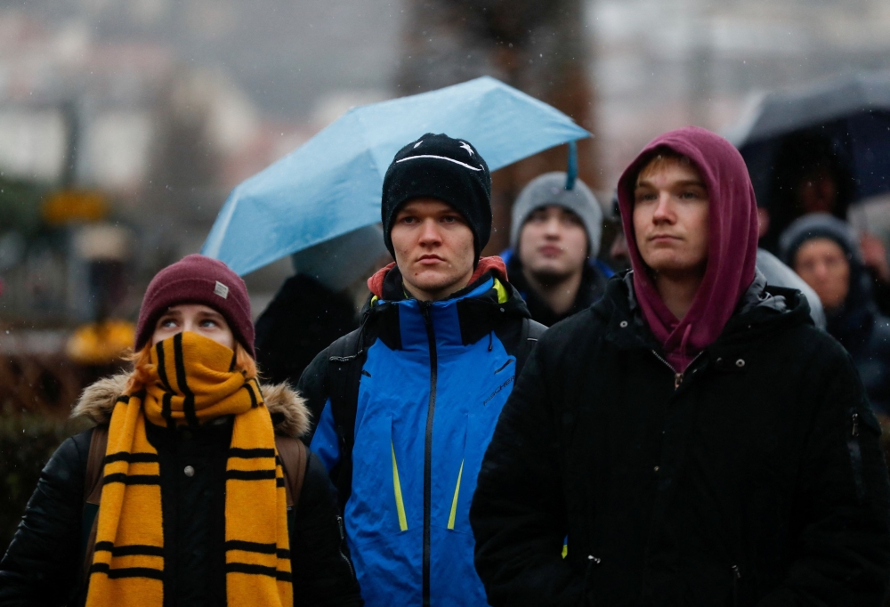 People observe a minute of silence commemorating the victims of a shooting at one of Charles University’s buildings, in front of the university, in Prague, Czech Republic, December 23, 2023. ― Reuters pic
