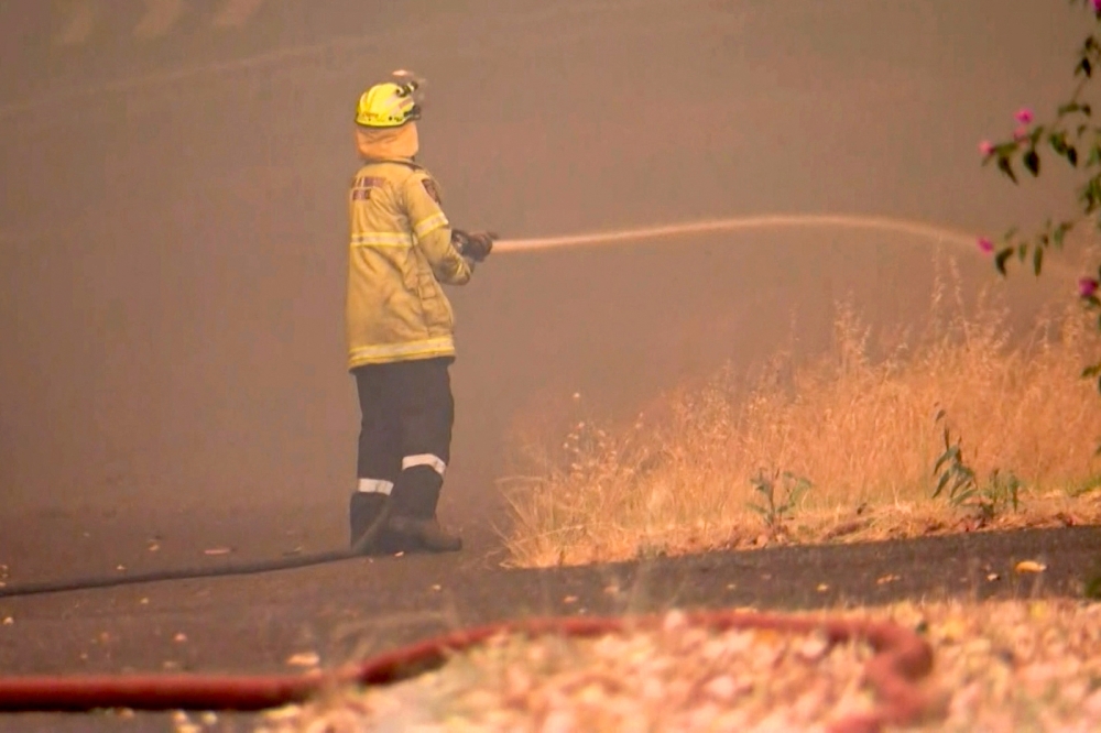 This frame grab from video footage taken and provided by Australian Broadcast Corporation (ABC) on December 21, 2023 via AFPTV shows firefighters in the suburb of Parkerville, east of Perth, attempting to put out a bushfire.  — AFP pic/Ten News/Australian Broadcast Corporation (ABC)