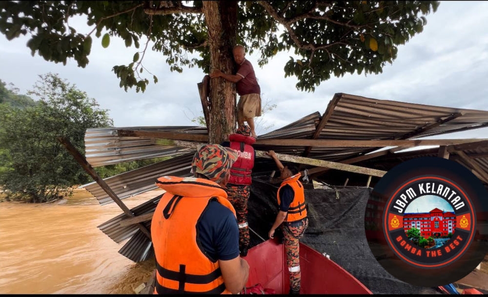 Firemen rescuing one of the flood victims who sought shelter in a tree in Gua Musang, Kelantan, December 25, 2023. — Picture from Facebook/JBPM Negeri Kelantan 
