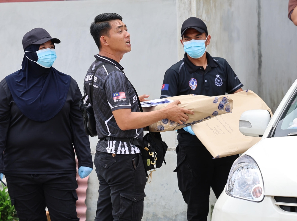 Forensic police carry evidence from a house in Taman Ungku Tun Aminah, near Skudai, December 24, 2023. — Bernama pic 