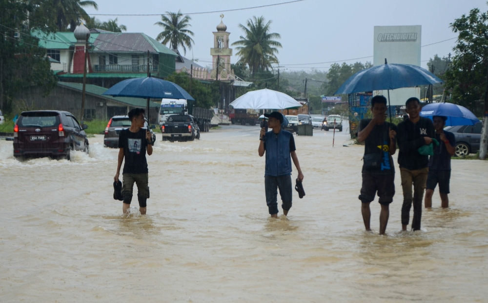 Residents wading through the flood at Jalan Jedok-Jeli following heavy rain since the previous night during a survey in Kampung Kelewek in Tanah Merah, December 25, 2023. — Bernama pic