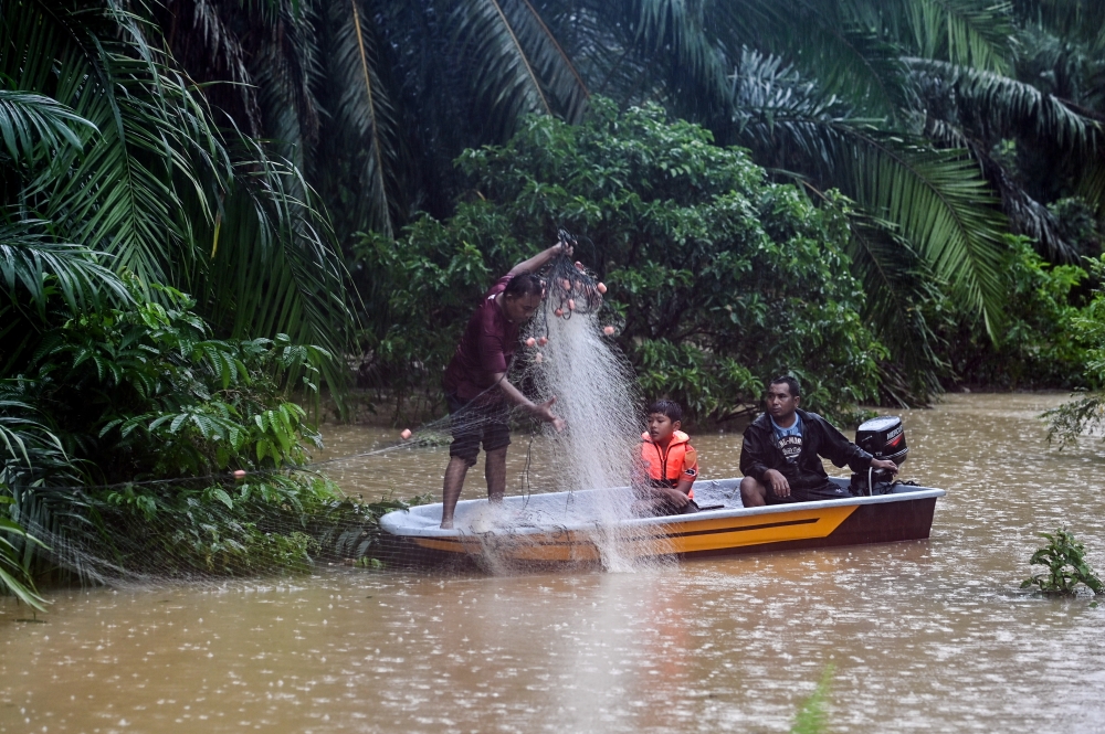 Residents taking the opportunity to set up nets after the area was flooded in Kampung Kepah in Kuala Berang, Terengganu, December 24, 2023. — Bernama pic
