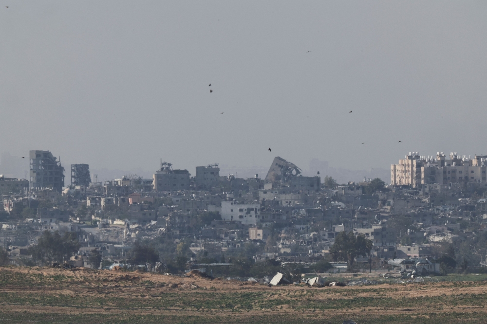 Birds fly as buildings lie in ruins in Gaza, amid the ongoing conflict between Israel and the Palestinian Islamist group Hamas, as seen from southern Israel, December 25, 2023. — Reuters pic