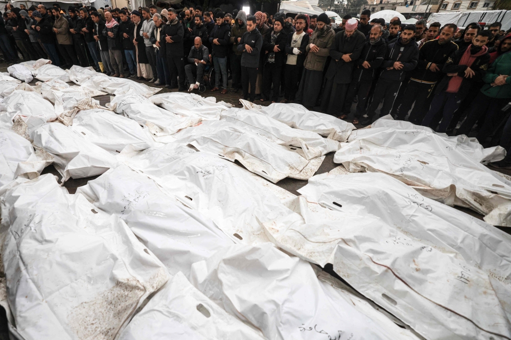 Rows of victims’ bodies, shrouded in white bags, lined the ground at Al-Aqsa hospital in Deir al-Balah, central Gaza, ahead of a mass funeral. — AFP pic