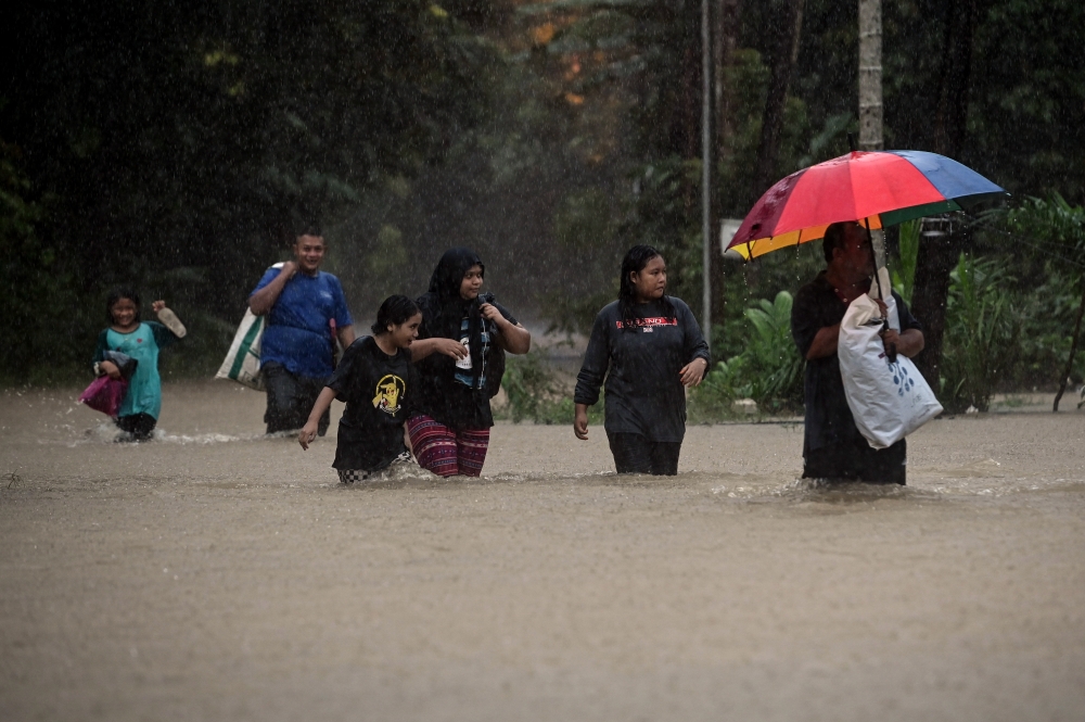 Flood victims evacuate their homes as waters rise in Kampung Shukor in Dungun December 25, 2023. — Bernama pic