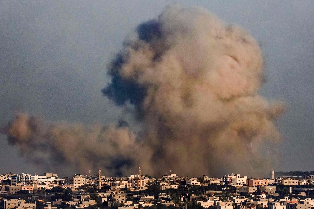  A smoke plume erupts over Khan Yunis from Rafah in the southern Gaza strip during Israeli bombardment on December 26, 2023, amid continuing battles between Israel and the Palestinian Hamas militant group. — AFP pic