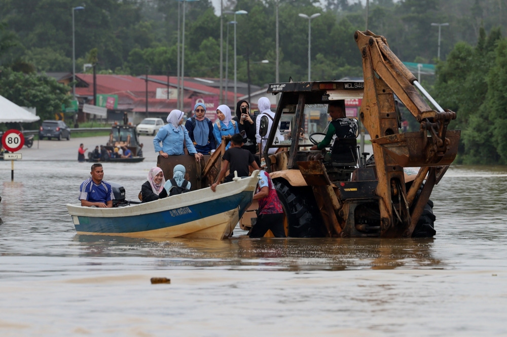 Staff are transported to the Hulu Terengganu Hospital via boat after the main road used to access the hospital was cut off due to rising flood water, in Kuala Berang December 27, 2023. — Bernama pic