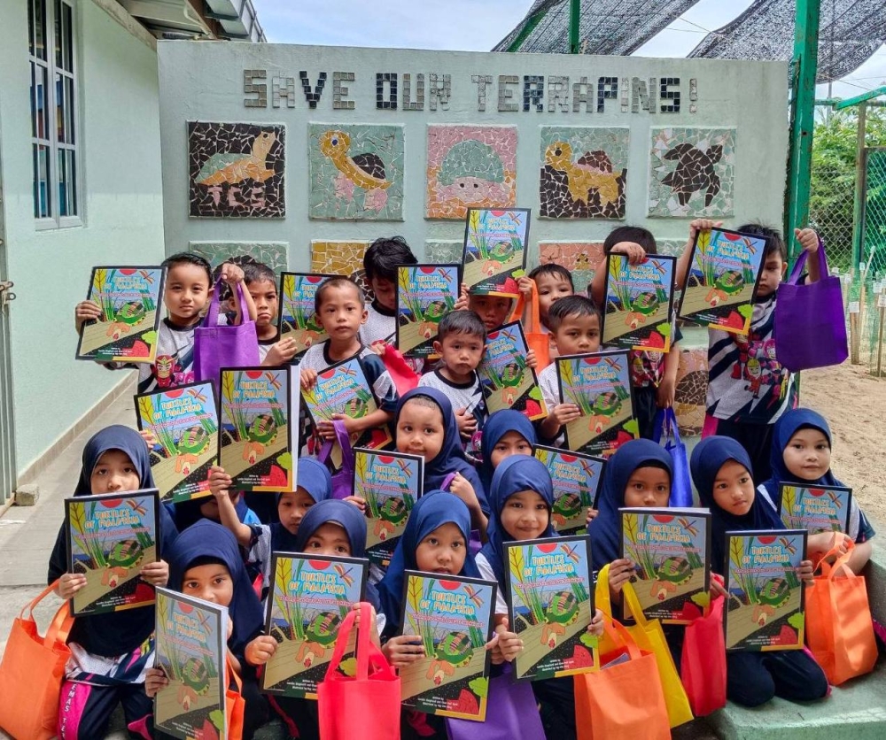 Preschoolers from Tabika KEMAS Teladas with their copy of 'Turtles of Malaysia' at TCS Terrapin Conservation Centre at Kampung Pasir Gajah, Kemaman, Terengganu last May. — Picture courtesy of TCS