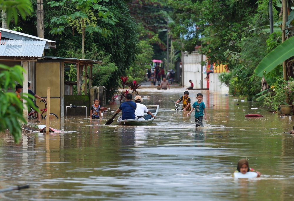 Children play in floodwater at Kampung Manek Urai in Kuala Krai, Kelantan, December 26, 2023. — Bernama pic  