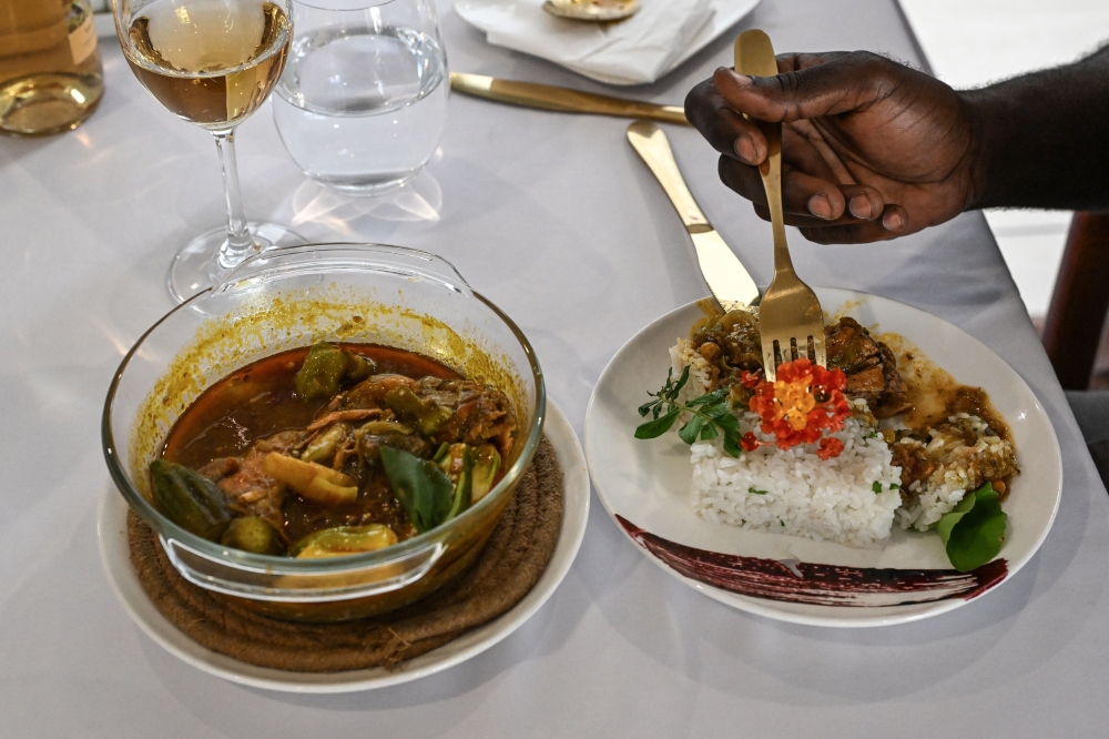 A customer eats rabbit gouagouassou sauce accompanied by rice, made by Ivorian chef Charlie Koffi, at the Villa Alfira restaurant in Abidjan on December 4, 2023. — AFP pic 
