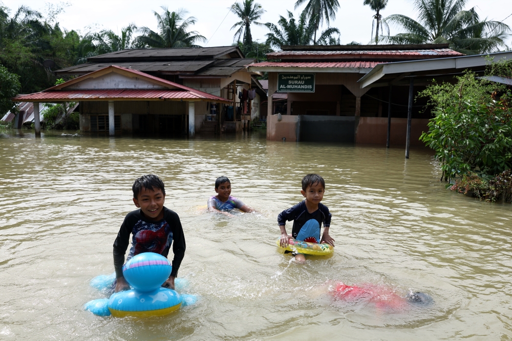 Children play in floodwaters in Pasir Mas December 28, 2023. ― Bernama pic