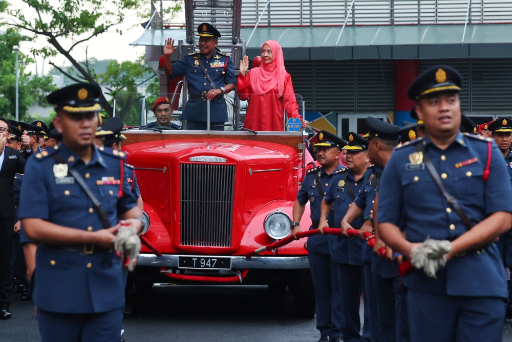 Malaysian Fire and Rescue Department director-general Datuk Seri Abdul Wahab Mat Yasin and his wife Datin Seri Nor Latifah Jaafar board a ceremonial vehicle pulled by senior officers at JBPM Putrajaya headquarters, December 29, 2023. — Bernama pic 
