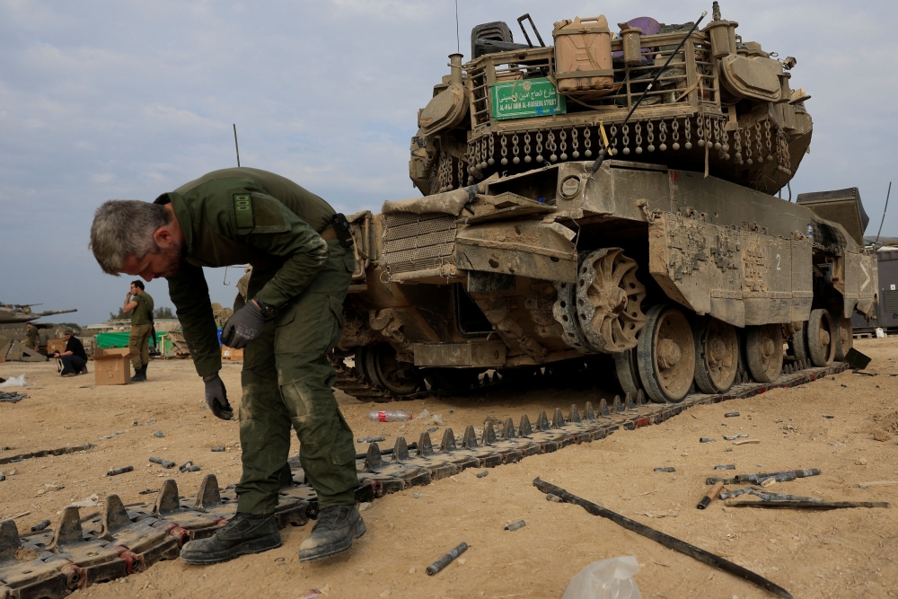Israeli soldiers work to repair tanks amid the ongoing conflict between Israel and the Palestinian Islamist group Hamas, near the Israel-Gaza border, in southern Israel December 28, 2023. — Reuters pic