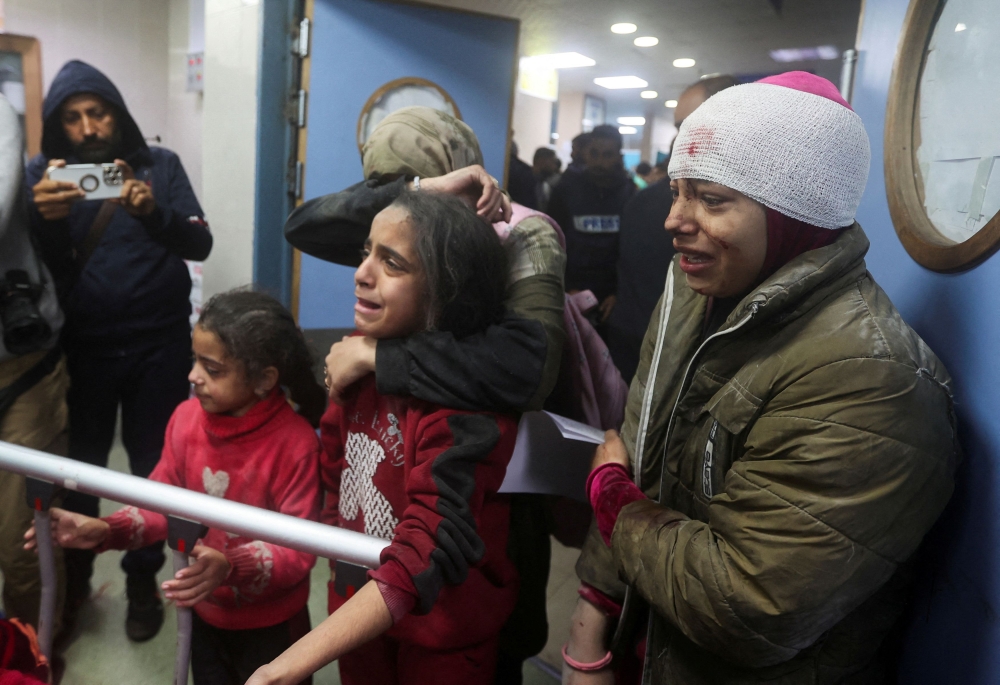 People react next to the bed of a Palestinian wounded in an Israeli strike, at a hospital in Khan Younis, amid the ongoing conflict between Israel and the Palestinian Islamist group Hamas, in the southern Gaza Strip, December 28, 2023. — Reuters pic