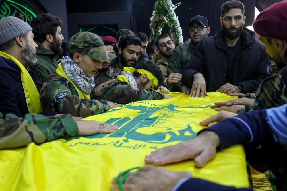 File photo of Comrades of Hezbollah member Hadi Hassan Awala, who was killed in southern Lebanon amid ongoing cross-border tensions between Israel and Hezbollah, mourning over his casket during his funeral in the southern suburb of Beirut on December 27, 2023, as fighting continues between Israel and Hamas militants in the Gaza Strip. — AFP pic