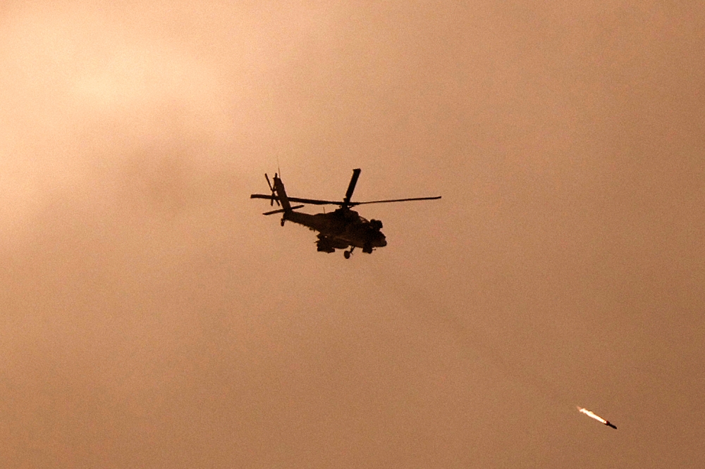 A picture taken from a position in southern Israel along the border with the Gaza Strip on December 29, 2023 shows an Israeli military helicopter firing a missile towards Gaza amid continuing battles between Israel and the militant group Hamas. — AFP pic