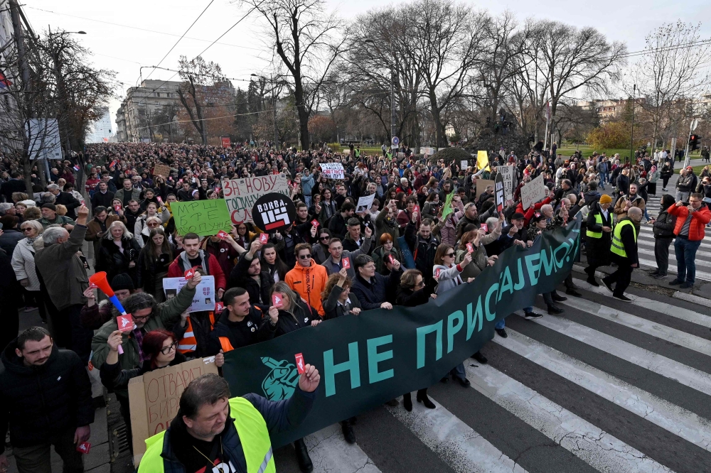 Protester hold a banner and rise stickers reading ‘We don’t accept!’, as they attend a rally of ‘ProGlas’, a Serbian pro-democracy movement, to protest against alleged electoral fraud, in Belgrade, on December 30, 2023. — AFP pic