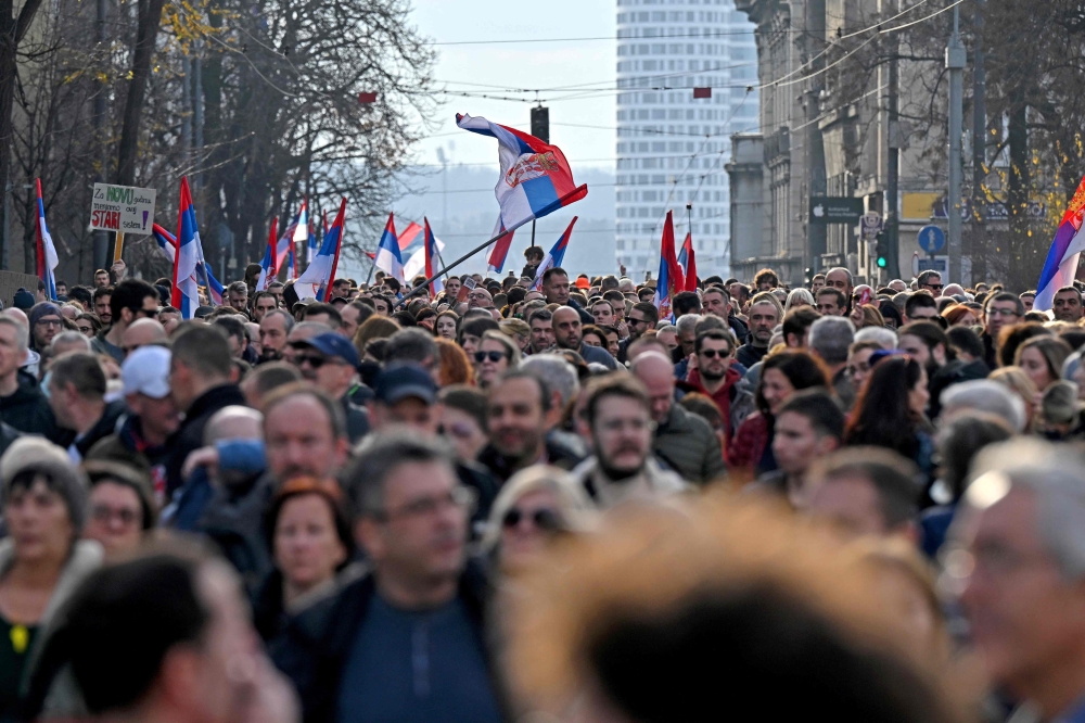 Protesters wave Serbian flags as they attend a rally of ‘ProGlas’, a Serbian pro-democracy movement, to protest against alleged electoral fraud, in Belgrade, on December 30, 2023. — AFP pic