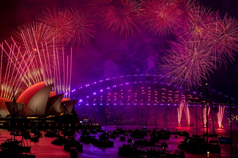 Fireworks explode over the Sydney Harbour Bridge and Sydney Opera House (L) during New Year's Eve celebrations in Sydney on January 1, 2024. — AFP pic