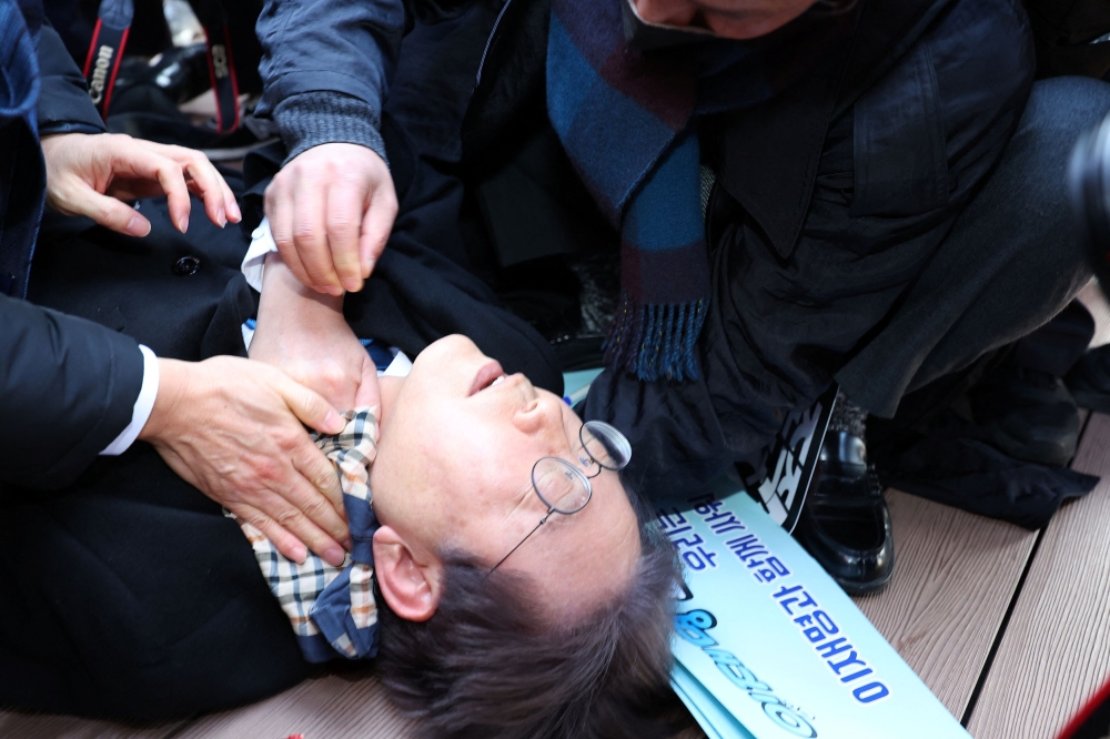 South Korea's opposition party leader Lee Jae-myung falls after being attacked by an unidentified man during his visit to Busan, South Korea January 2, 2024. ― Yonhap via Reuters
