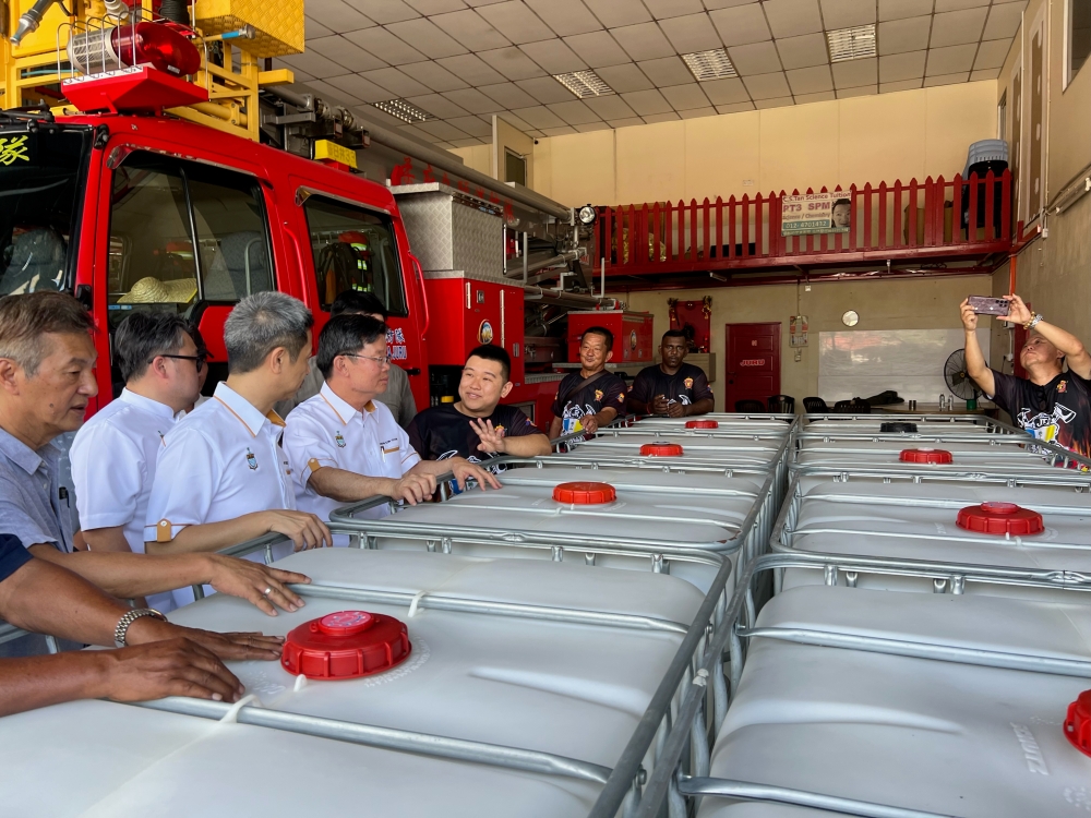Penang Chief Minister Chow Kon Yeow (fourth from left) and Bukit Tengah assemblyman Gooi Hsiao-Leung (third from left) looking at the plastic water tanks at the Juru Volunteer Fire Brigade January 2, 2024 — Picture by Opalyn Mok