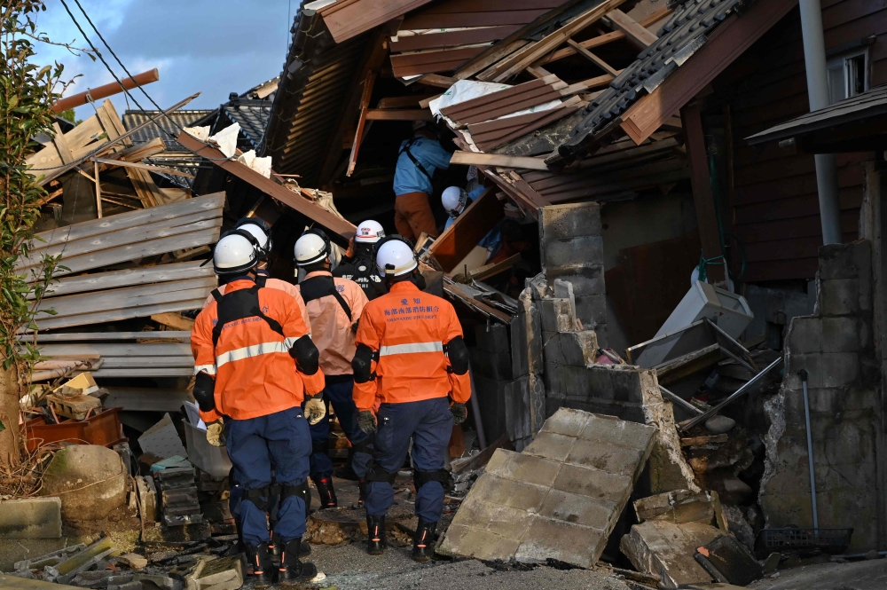 Firefighters inspect collapsed wooden houses in Wajima, Ishikawa prefecture on January 2, 2024, a day after a major 7.5 magnitude earthquake struck the Noto region in Ishikawa prefecture in the afternoon. ― AFP pic