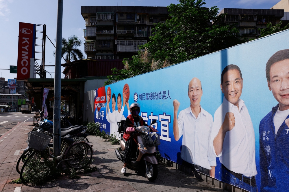 A person drives past a campaign ad for Hou Yu-ih, a candidate for Taiwan's presidency, from the main opposition party Kuomintang (KMT) ahead of the presidential election in Taipei City, Taiwan January 2, 2024. ― Reuters pic