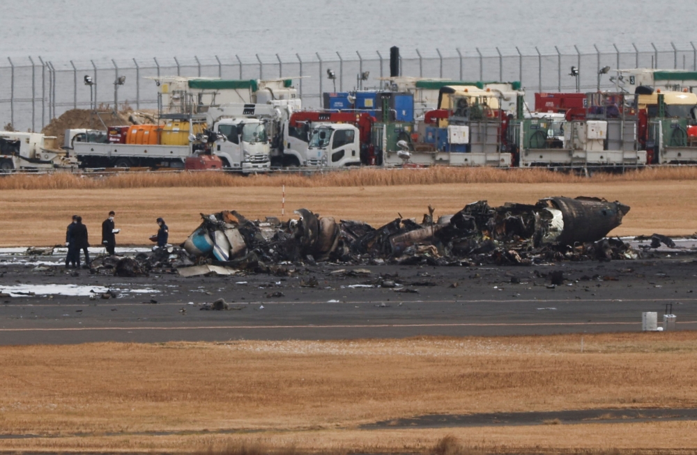 Officials investigate a burnt Japan Coast Guard aircraft after a collision with Japan Airlines' (JAL) Airbus A350 plane at Haneda International Airport in Tokyo, Japan January 3, 2024. ― Reuters pic