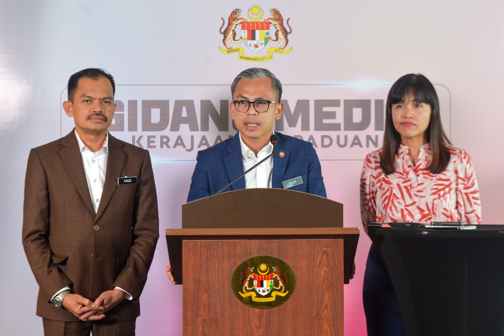 Communications Minister Fahmi Fadzil (centre) speaks to the media during a press conference at the Communications Ministry in Putrajaya January 3, 2024. — Picture by Shafwan Zaidon