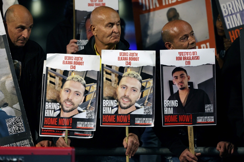 Relatives and supporters hold placards bearing portraits of Israeli hostages held in Gaza since the October 7 attacks by Hamas in southern Israel, during a rally calling for their release, in Tel Aviv on December 30, 2023. — AFP pic