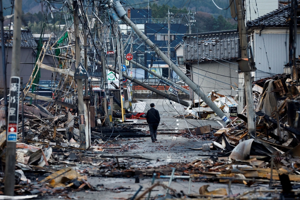 A man makes his way along Asaichi-dori street, which burned down due to a fire following an earthquake, in Wajima, Japan, January 4, 2024. — Reuters pic