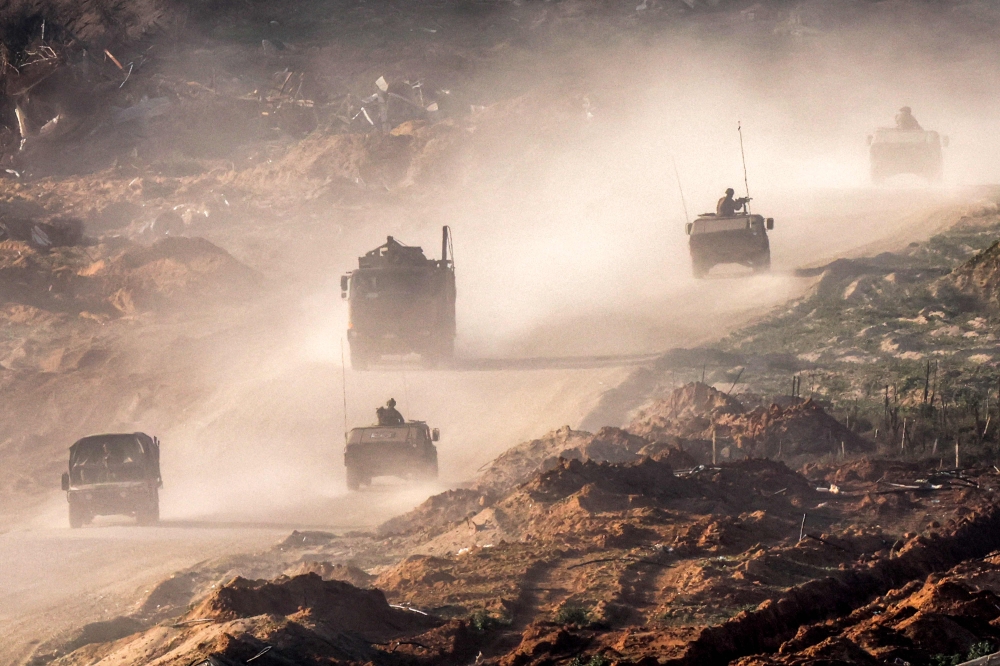 Israeli army humvees and vehicles move along a dirt road in the Gaza Strip near a position along the border with southern Israel on January 4, 2024, amid the ongoing conflict between Israel and the Palestinian militant group Hamas. — AFP pic