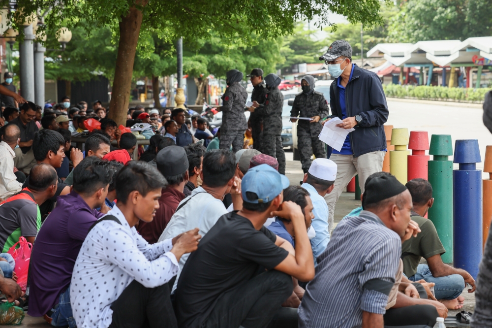 Terengganu Immigration Department director Azhar Abdul Hamid (right) inspects the documents of migrants detained during ‘Op Kutip’ at the Kuala Terengganu City Council Bus Terminal January 5, 2024. — Bernama pic 