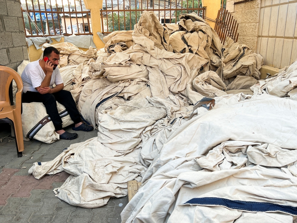 A Palestinian man speaks on the phone next to tents which the Kuwaiti hospital said it received without poles, as the entry of the poles was banned into Gaza by Israel, in Rafah, southern Gaza Strip, December 24, 2023. — Reuters pic  