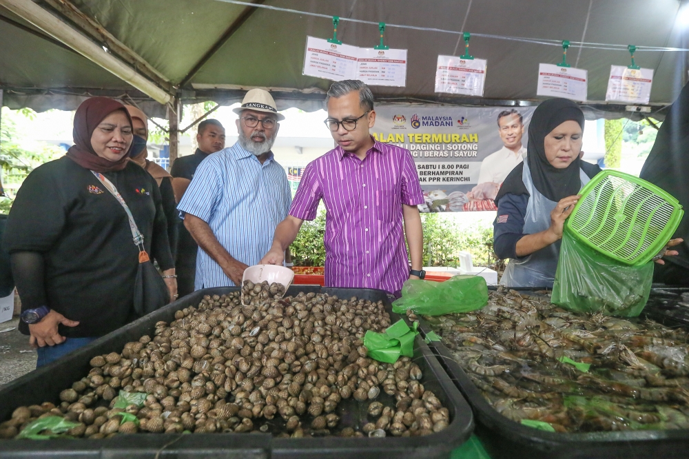 Communications Minister, who is also Lembah Pantai MP, Fahmi Fadzil (centre) during a visit to the Jualan Termurah Demi Rakyat in Kerinchi, Kuala Lumpur January 6, 2024. — Picture by Yusof Mat Isa