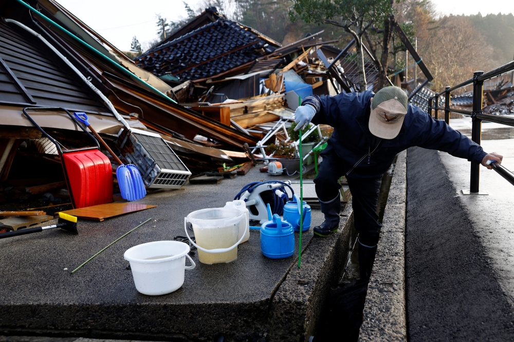 Yutaka prepares to collect water from sewage for use in a toilet, in the aftermath of an earthquake, in Wajima, Ishikawa Prefecture, Japan January 6, 2024. ― Reuters pic