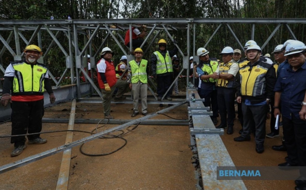 Works Minister Datuk Seri Alexander Nanta Linggi surveys the site of the Bailey bridge currently under construction at KM73.850 of Jalan Kampung Sungai Sam-Jeli in Jeli January 6, 2024. — Picture via X/Bernama 