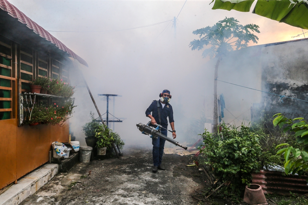 File picture of a worker fogging a residential area to prevent the spread of dengue in Kulim, Kedah. The Sabah Health Department yesterday said that 6,983 dengue cases were reported until the 52 Epidemiology week. — Picture by Firdaus Latif
