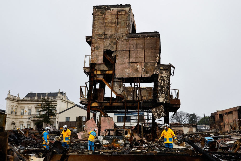 Policemen search for victims in Asaichi-dori street, which burned down due to a fire following an earthquake in Wajima, Ishikawa Prefecture, Japan, January 7, 2024. — Reuters pic 