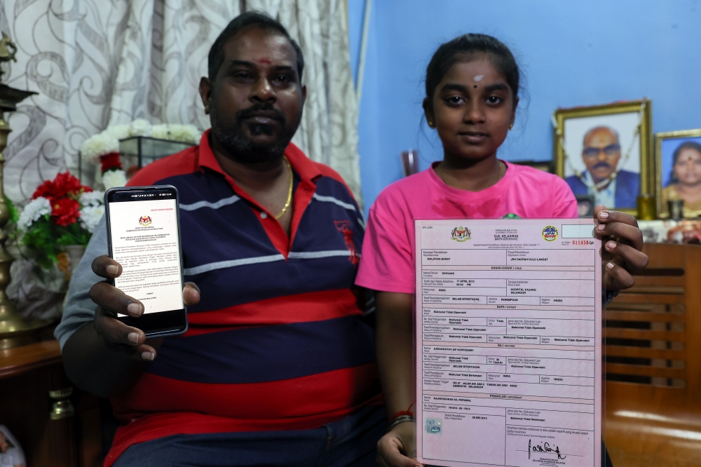 R. Shivani and her father P. Rajheswaran, 44, shows the media statement and her birth certificate when interviewed about being able to return to school for this year’s session, after a year of not attending school due to citizenship status issues. — Bernama pic 