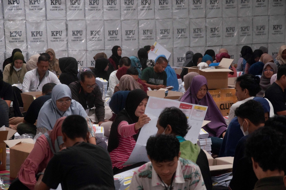 People fold ballot papers for the 2024 general elections at the General Election Commission in Pekanbaru, Riau province on January 7, 2024. — AFP pic