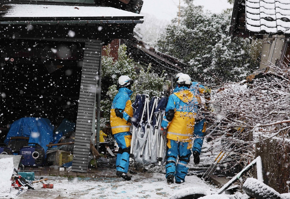 Rescuers conduct searches for survivors as snow hampers rescue operations in the city of Suzu, Ishikawa prefecture on January 7, 2024. — AFP pic