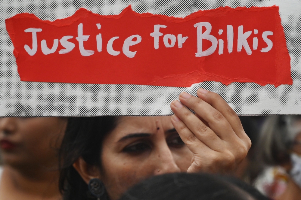 A woman holds a placard during a protest against the release of men convicted of gang-raping Bilkis Bano during the 2002 communal riots in Gujarat, in Mumbai on August 23, 2022. — AFP pic