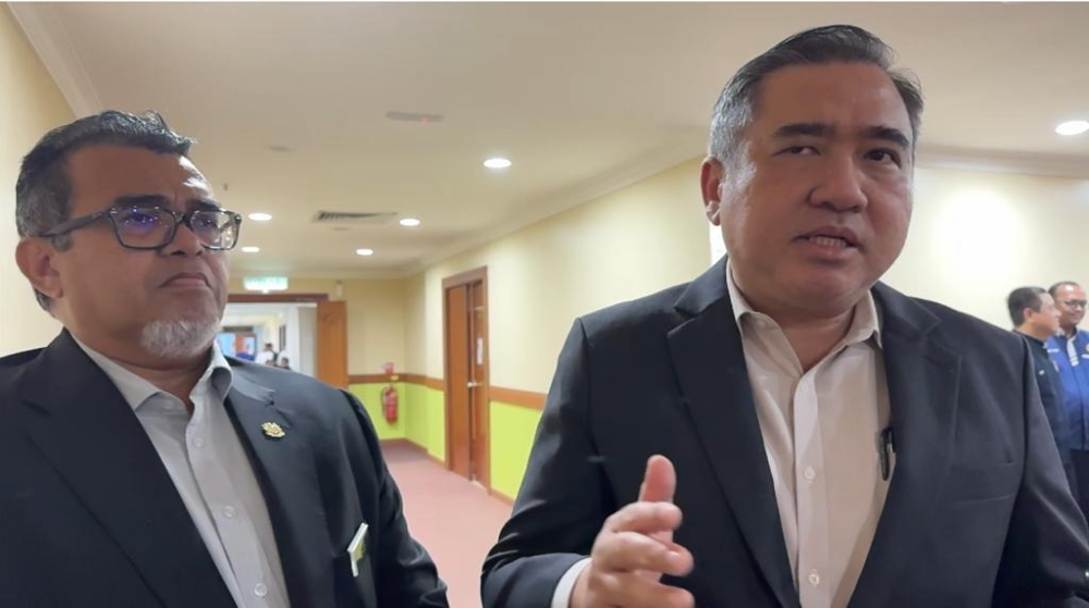 Transport Minister Anthony Loke (right) speaks to reporters after the meeting. Looking on is Hasbi. ― Borneo Post pic