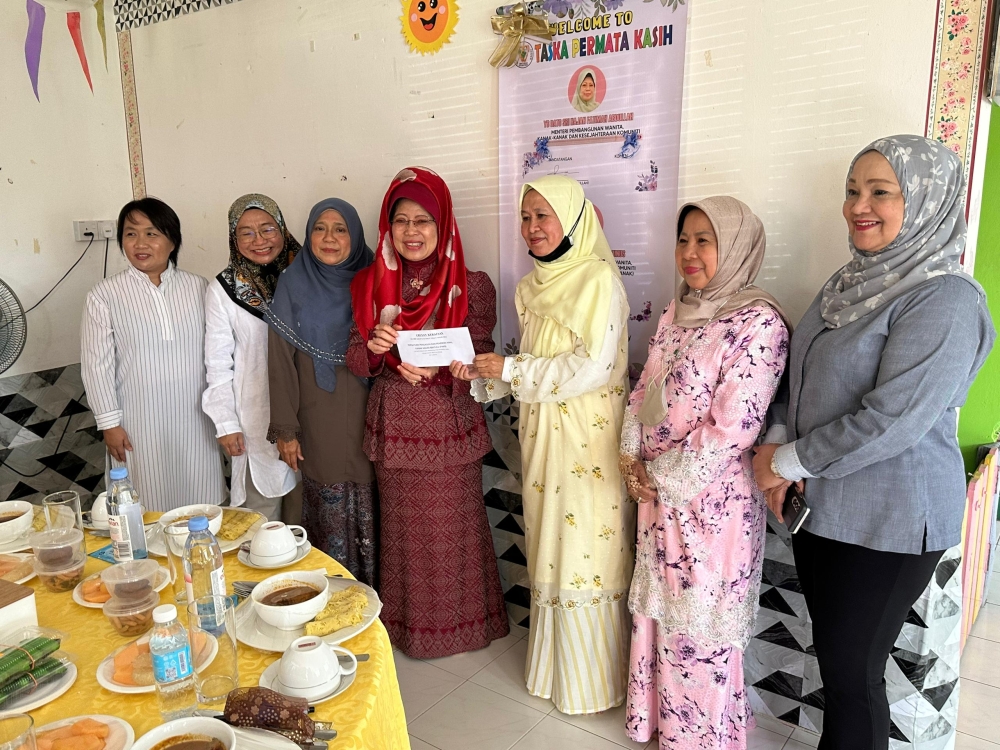 Fatimah (fourth, left) presenting the cheque to PAKB chairperson Maraini Jaafar as others look on. ― Borneo Post pic