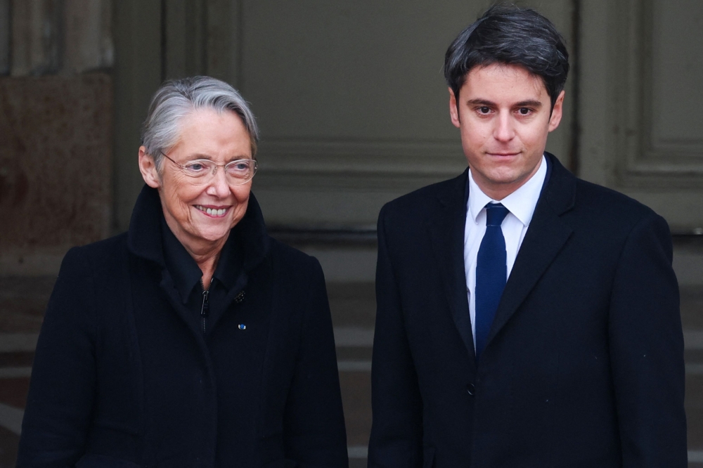 Newly appointed Prime minister Gabriel Attal (right) is welcomed by outgoing Prime minister Elisabeth Borne as he arrives for the handover ceremony at the Hotel Matignon in Paris January 9, 2024. — Ludovic Marin/Pool/AFP pic 