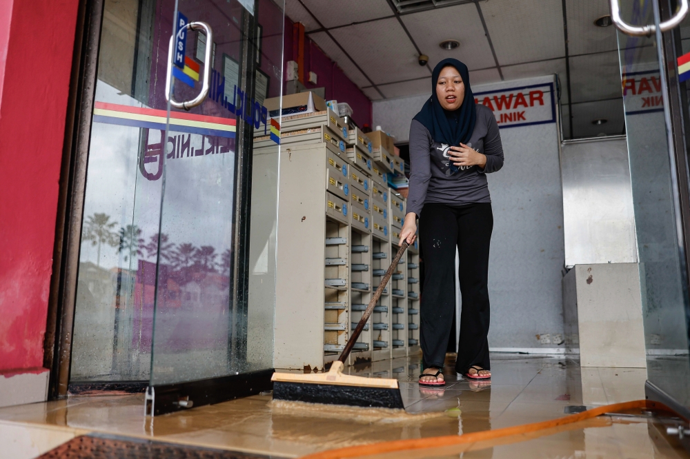 A woman cleans up a shop after floodwaters recede in Kota Tinggi, January 10, 2024. — Bernama pic 