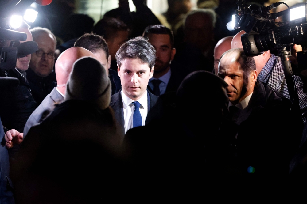 Newly appointed French Prime minister Gabriel Attal (centre) speaks with local residents during a visit to Clairmarai January 9, 2024. — AFP pic 